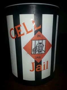 a black and white bucket with an orange logo on the side that says cell in jail