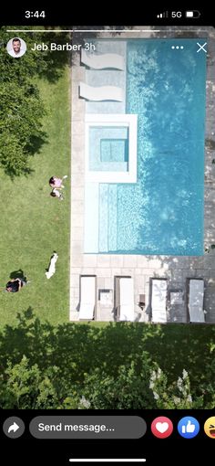 an aerial view of a pool and lawn with people laying on the grass near it