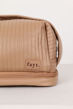 Introducing the latest Fayt makeup bag. The perfect cosmetic bag to carry all your go-to products, brushes and skincare faves. Featuring a zip top with a large capacity inside and handy carry handle on top, as well as a separate brush compartment on the base and a cover to keep all your brushes from transferring. What more could you want from a makeup case! Why you'll love our Makeup Bag: Featuring a cute carry handle and zip top - she is convenient and easy to travel with Unzip the bottom compartment to store even more goodies! Comes with a separate makeup brush storage component Made from a super soft, squishy faux leather fabric and in the cutest coffee colour - we are obsessed! The details: Zip up make-up bag Soft PU Leather Separate brush compartment on the base Handle on top Cute pat Versatile Beige Rectangular Cosmetic Bag, Beige Rectangular Cosmetic Bag, Beige Travel Cosmetic Bag With Zipper, On-the-go Beige Zipper Cosmetic Bag, Eco-friendly Rectangular Cosmetic Bag With Zipper, Brush Storage, Makeup Brush Storage, Faux Leather Fabric, Coffee Colour