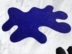 a blue rug is on the floor next to a person's feet