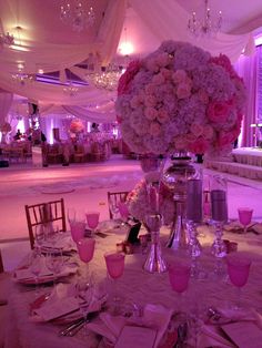 a table set with pink flowers and place settings