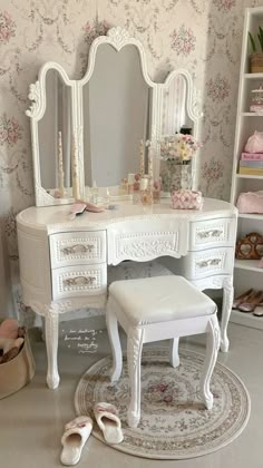 a white dressing table with a stool and mirror