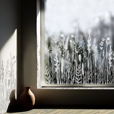 a vase sitting next to a window with frost on it