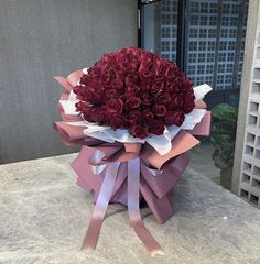 a bouquet of red roses sitting on top of a table