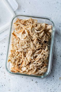 shredded chicken in a glass dish on a counter