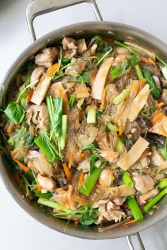 a pan filled with meat and vegetables on top of a stove