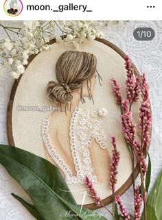 a cross stitch pattern on a wooden hoop with flowers and greenery