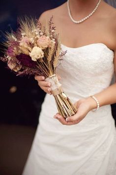 a woman in a wedding dress holding flowers