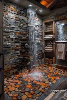 a bathroom with stone walls and a waterfall in the shower area, surrounded by rocks