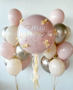 a bunch of balloons with the words hello spring written on them in gold, silver and pink