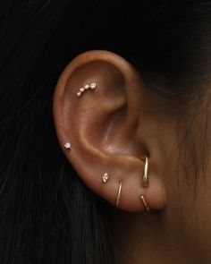 a woman's ear with three different types of piercings on her left side