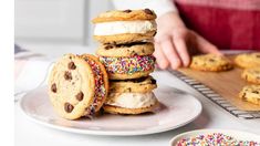 a stack of cookies with sprinkles and chocolate chip cookie sandwiches on a plate