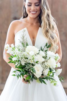 a woman holding a bouquet of white flowers