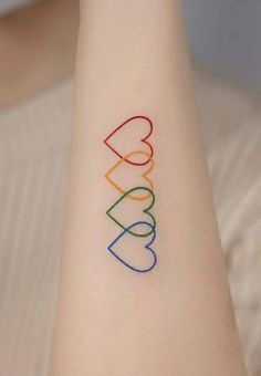 a person with a tattoo on their arm that has the word love written in different colors