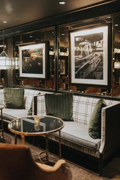 a living room with couches, tables and pictures on the wall in it's corner