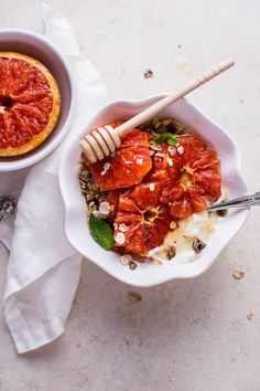 a bowl filled with food next to a spoon on top of a white table cloth