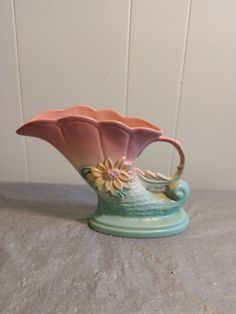 a ceramic flower vase sitting on top of a table