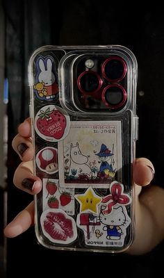 someone holding up their cell phone case with stickers on the front and back sides