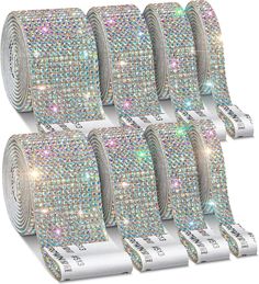 six rolls of sequinized ribbon with white and multicolored crystals on them