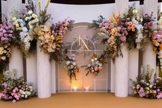 a decorated stage with flowers and candles for a wedding or special event, in front of an arch