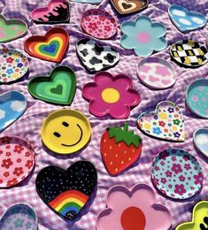 many heart shaped plates on a table with flowers, hearts and smiley faces painted on them