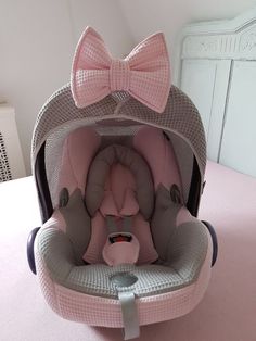 a baby car seat with a pink bow on it