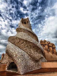 a large building made out of rocks under a cloudy sky