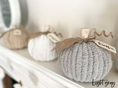 three knitted pumpkins sitting on top of a mantle