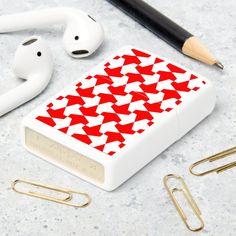 an apple airpods case with red and white hounds on it next to earphones