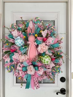 a pink and green easter wreath on the front door