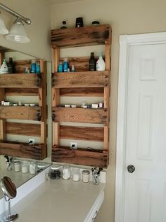 a bathroom sink sitting under a mirror next to a wooden shelf