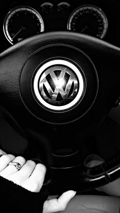 the steering wheel and dashboard of a volkswagen car is seen in this black and white photo