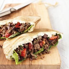 two burritos cut in half on a cutting board