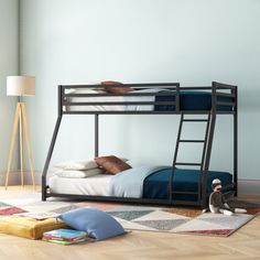 a bunk bed sitting on top of a hard wood floor next to a lamp and rug