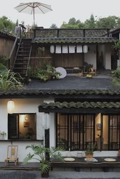 an outside view of a house with plants on the roof and stairs leading up to it