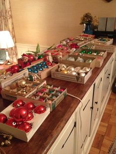 a kitchen counter covered in boxes filled with christmas ornaments and ornaments on top of it