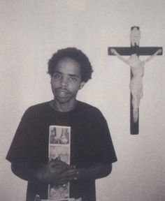 a man standing in front of a crucifix with pictures on it's chest