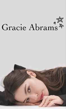 a woman laying on top of a white table next to a star sign with the words grace abrahams