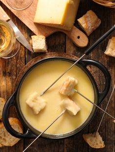 cheese sticks sticking out of a fondant in a pot with bread on the side