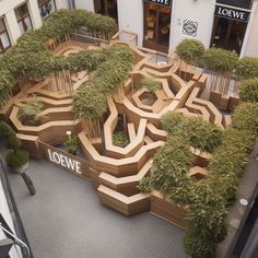 an aerial view of a building with trees in the center and bushes growing out of it