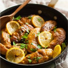 a skillet filled with lemon chicken and garnished with parsley