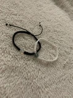 two black and white bracelets laying on top of a bed