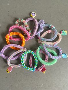 several colorful bracelets laid out on the ground with one knot in the middle and two looped around each other