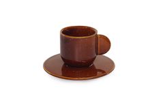 a brown cup and saucer sitting on top of a white surface with a small plate underneath it