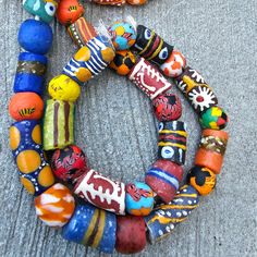 two bracelets made out of glass beads on the ground next to each other with different designs and colors