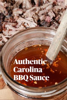 a jar filled with bbq sauce sitting on top of a cutting board next to meat