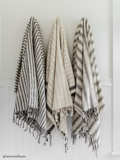 three black and white towels hanging on the wall