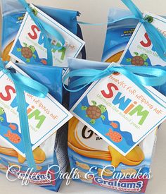 four bags of swim snacks wrapped in blue ribbon and tied with a bow on top