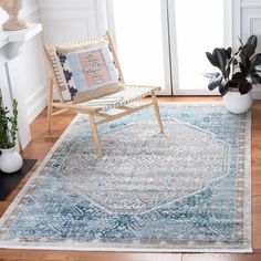 a living room area with a chair, rug and potted plant