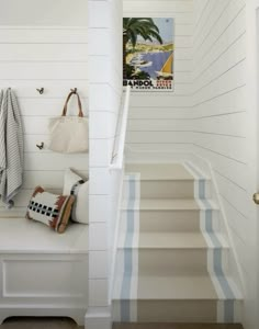 there is a white staircase with blue and white stripes on the carpeted flooring